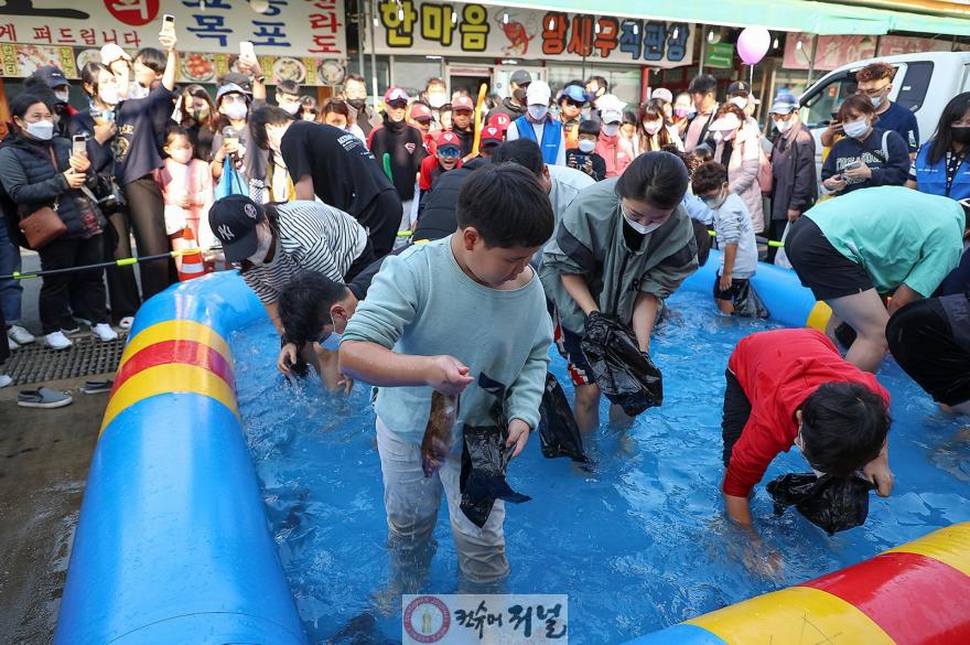기획보도 사진1 제10회 시흥월곶포구축제 중 맨손 고기잡이 체험에 참여 중인 시민들.jpg