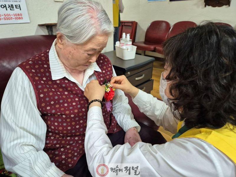 1_지난_12일_인천_부평구_한_경로당에서_신천지_자원봉사단_인천지부_봉사자가_어르신에게_카네이션을_달아드리고_있다.jpg